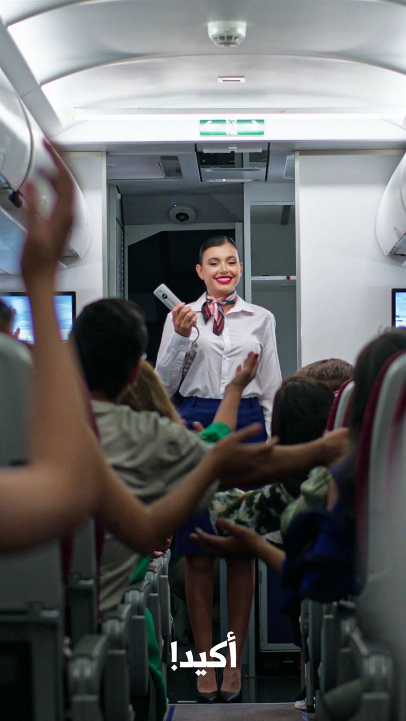 Frame from the Toothpick App commercial: a flight attendant in an airplane cabin
